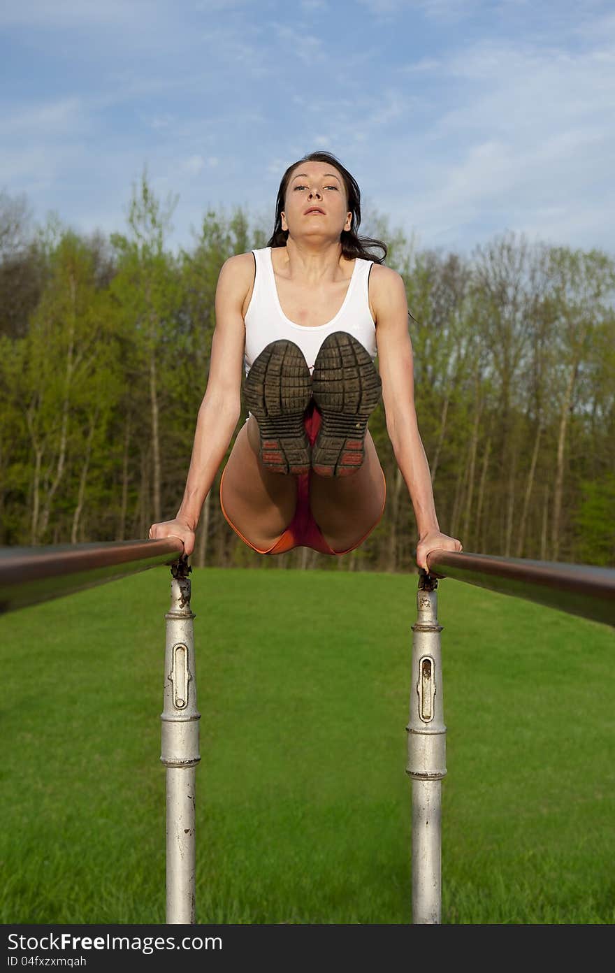 Woman on metal bar doing exercises, sport theme shot