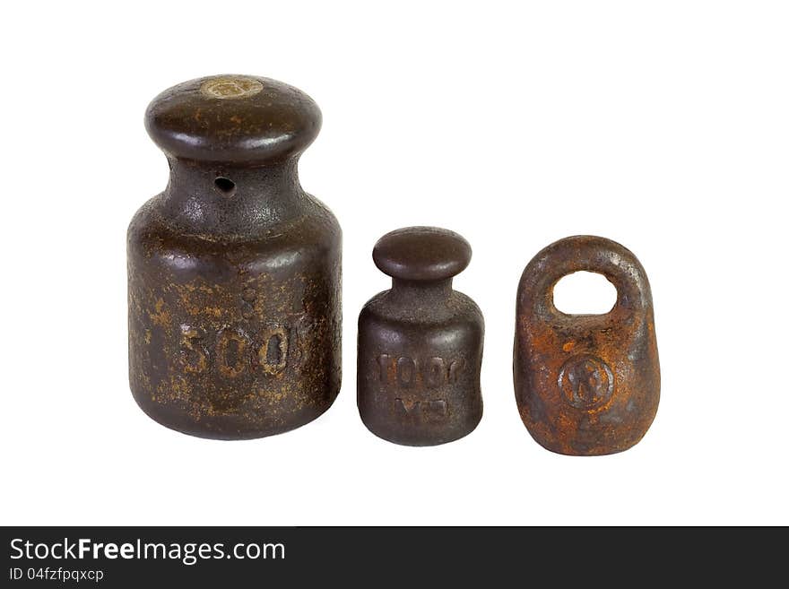 Three of the old weights for scales on a white background