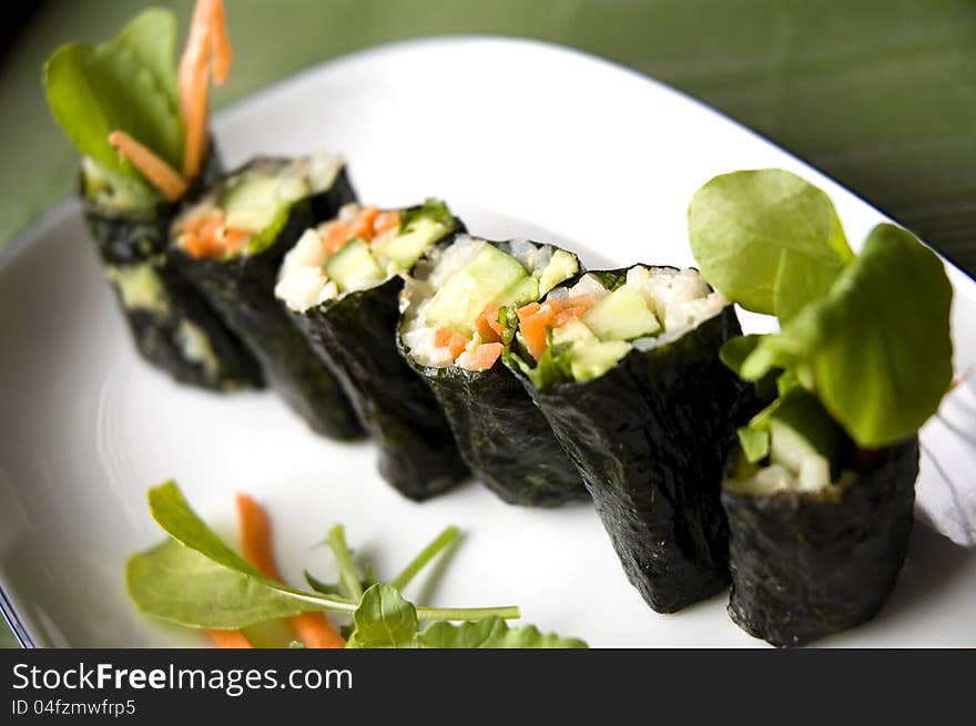 Close up vegetarian sushi roll on white plate. Close up vegetarian sushi roll on white plate