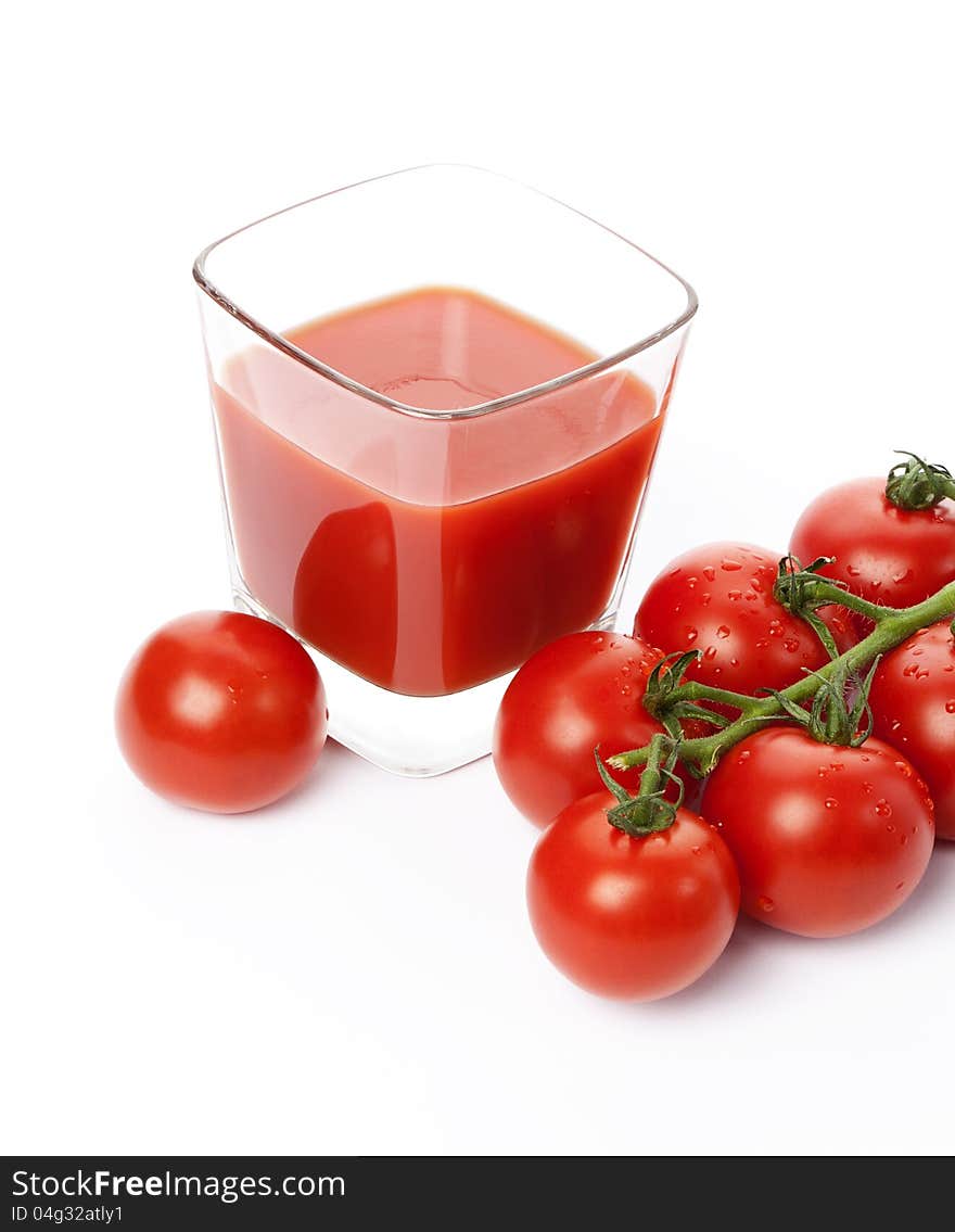 Fresh cherry tomatoes and a glass of tomato juice, isolated on white background