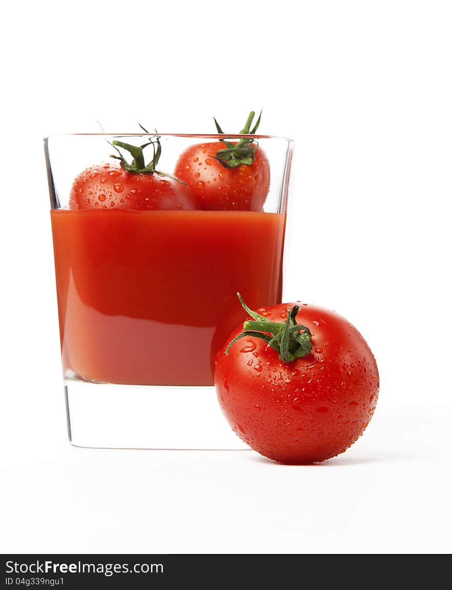 Fresh cherry tomatoes and a glass of tomato juice, isolated on white background