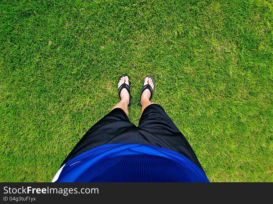 Unique perspective looking down at the earth with feet in the grass. Unique perspective looking down at the earth with feet in the grass.