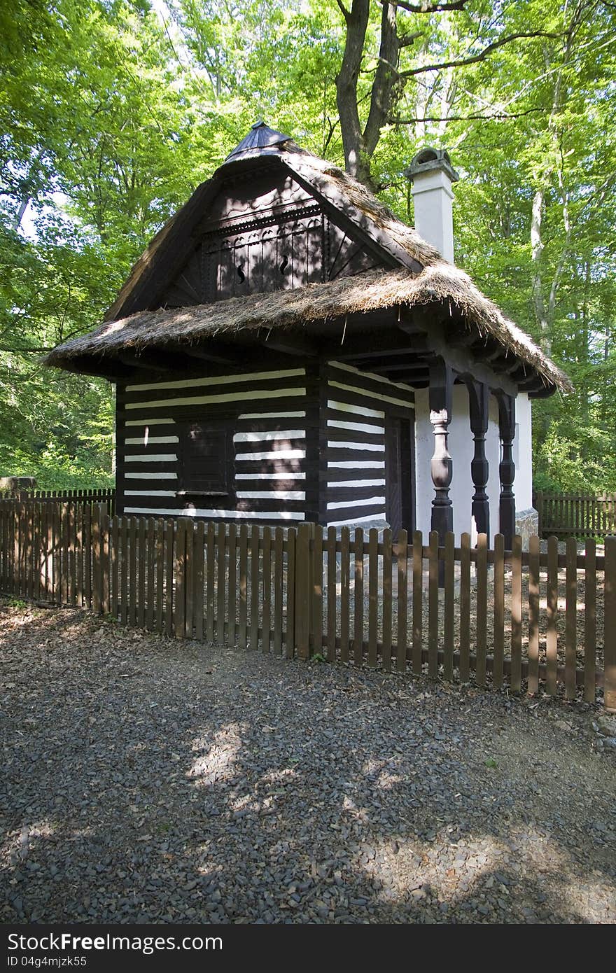 Cottage with a roof of straw and wooden fence