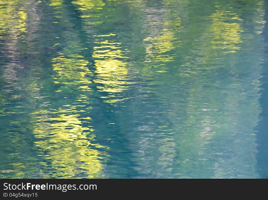 Reflections of trees in a smal blue lake - abstract background. Reflections of trees in a smal blue lake - abstract background