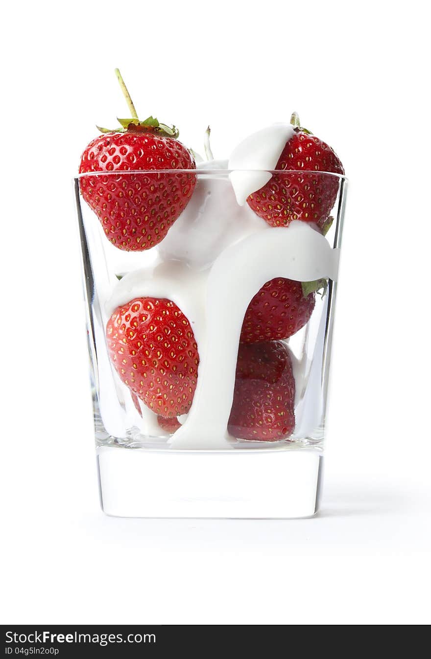 Ripe strawberries and milk in a beaker on a white background