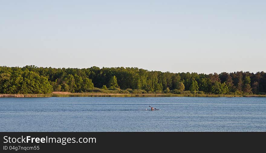 Blue sky and green trees in nature over lake with reflections