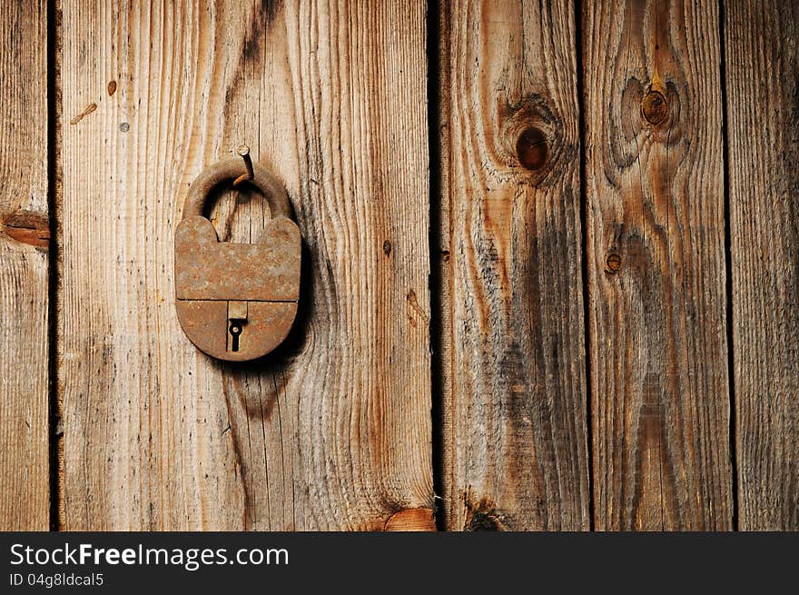 Old rusty padlock hanging on wooden wall. Old rusty padlock hanging on wooden wall