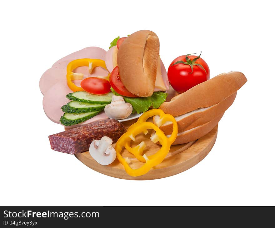 Sandwich with sausage and vegetables on plate, bread and vegetables on cutting board isolated on white background