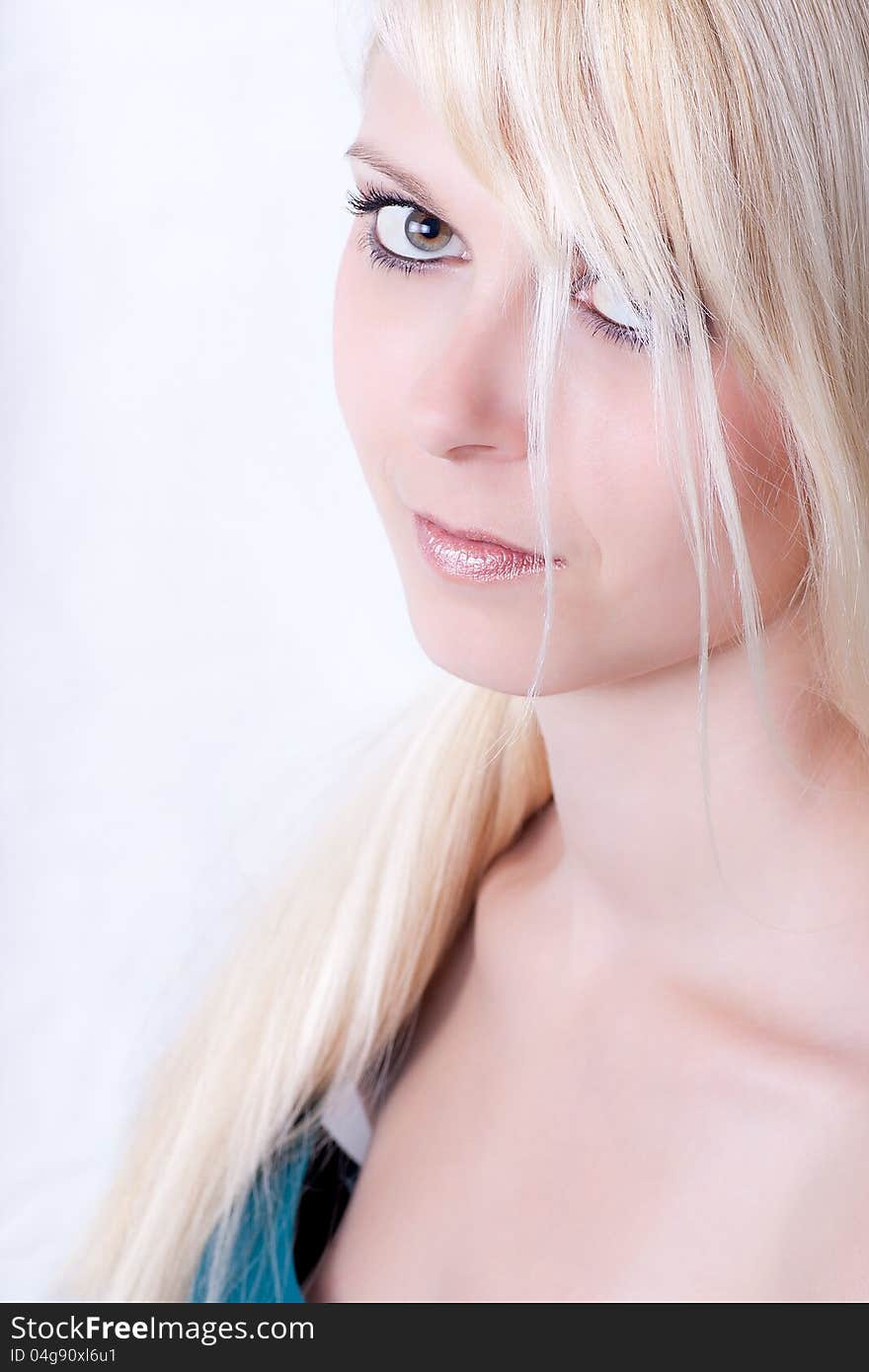 High key portrait of attractive young woman with long blond hair, studio background.