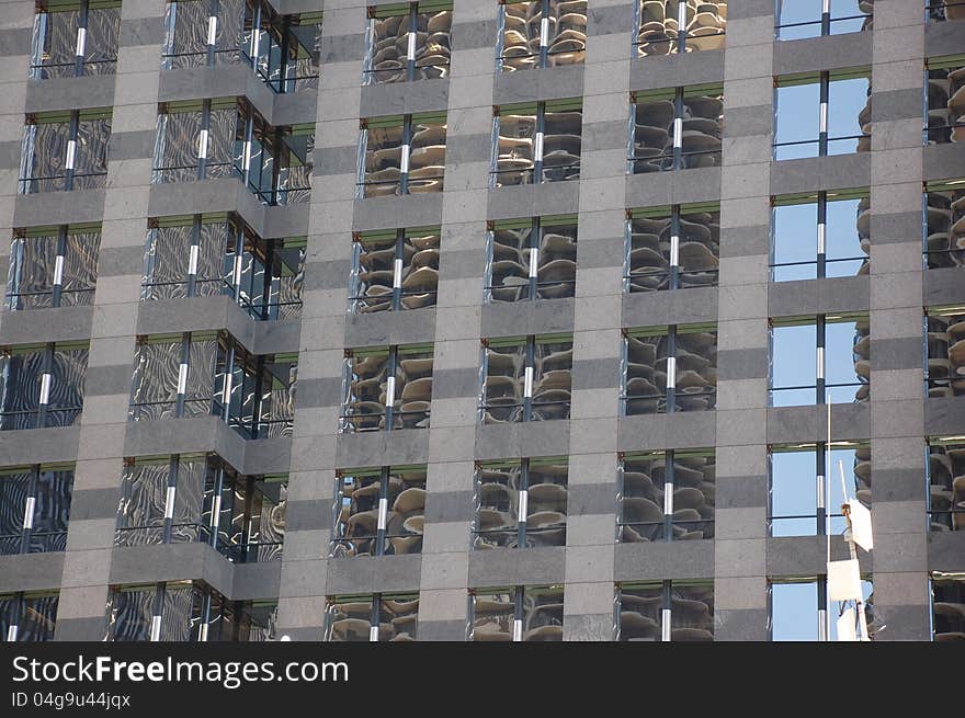 The glass windows of a modernly ornamented skyscraper at the Chicago River mirrors the opposite standing skyscrapers together with a vertical line of blue sky. The glass windows of a modernly ornamented skyscraper at the Chicago River mirrors the opposite standing skyscrapers together with a vertical line of blue sky.