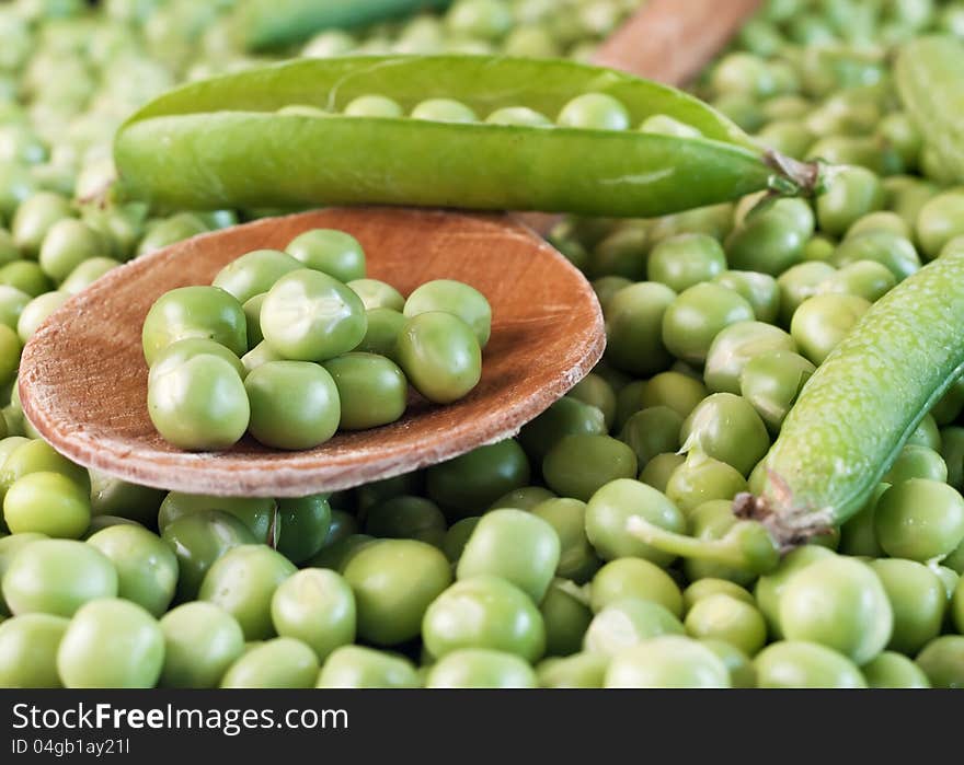 Fresh raw green pea seeds on wooden spoon,close up. Fresh raw green pea seeds on wooden spoon,close up