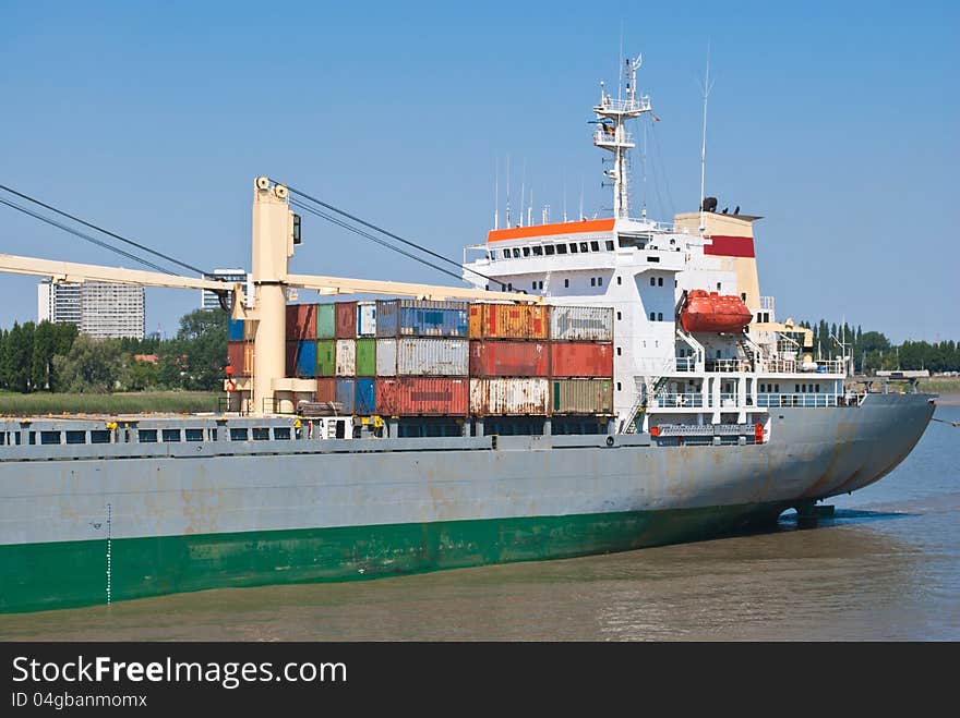 Cargo container ship - freighter navigating in river near Antwerpen. Poop view.