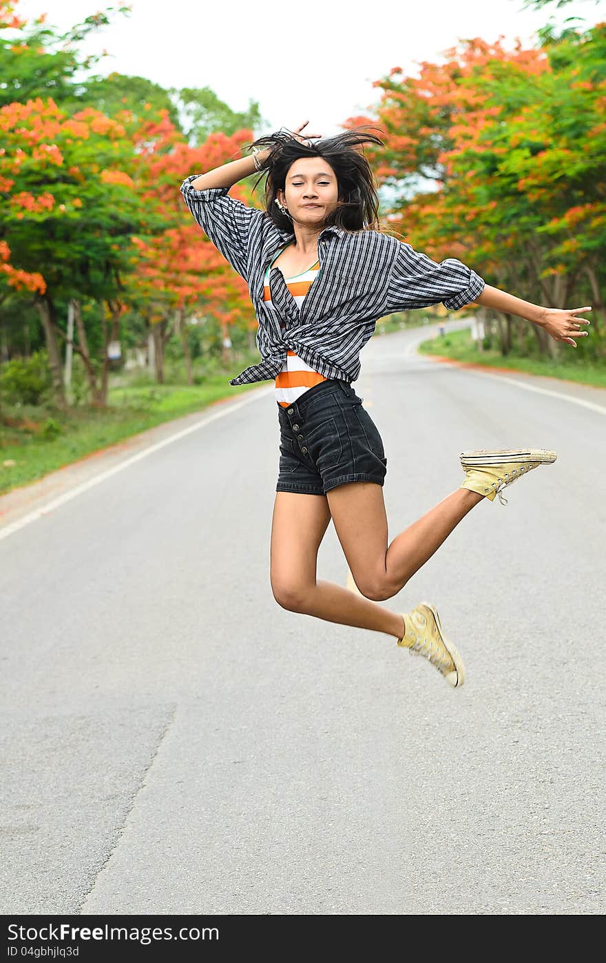 An attractive hitchhiker girl jumping