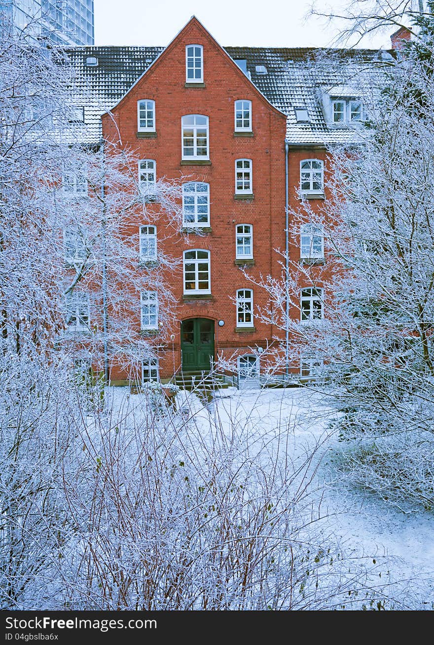 Old histirical brick apartment house in the winter season with frozen plants. Old histirical brick apartment house in the winter season with frozen plants.