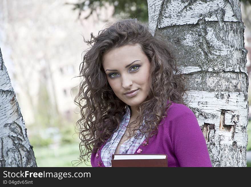 Young student in park with book