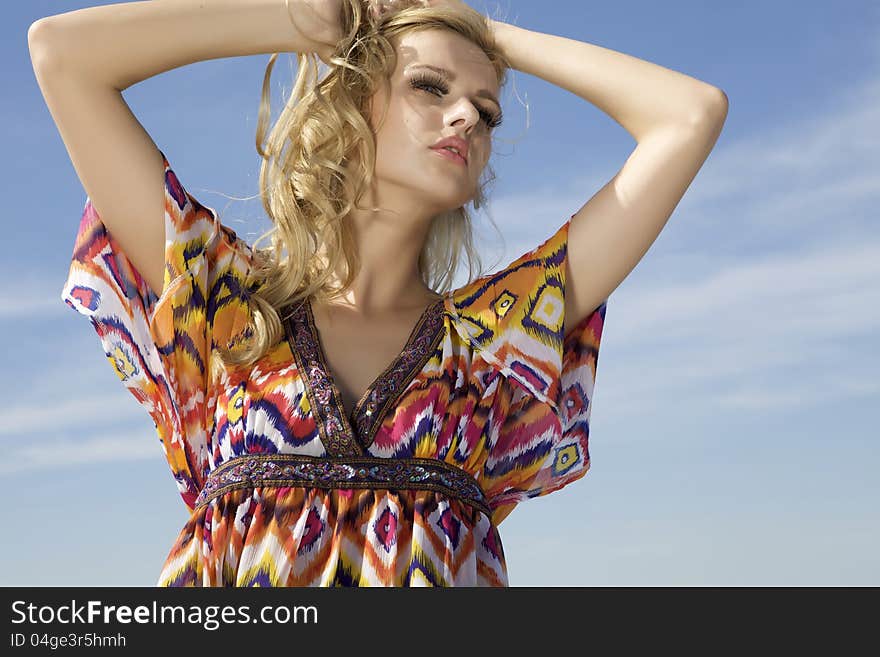 Portrait of beautiful blonde girl on background blue sky. Portrait of beautiful blonde girl on background blue sky