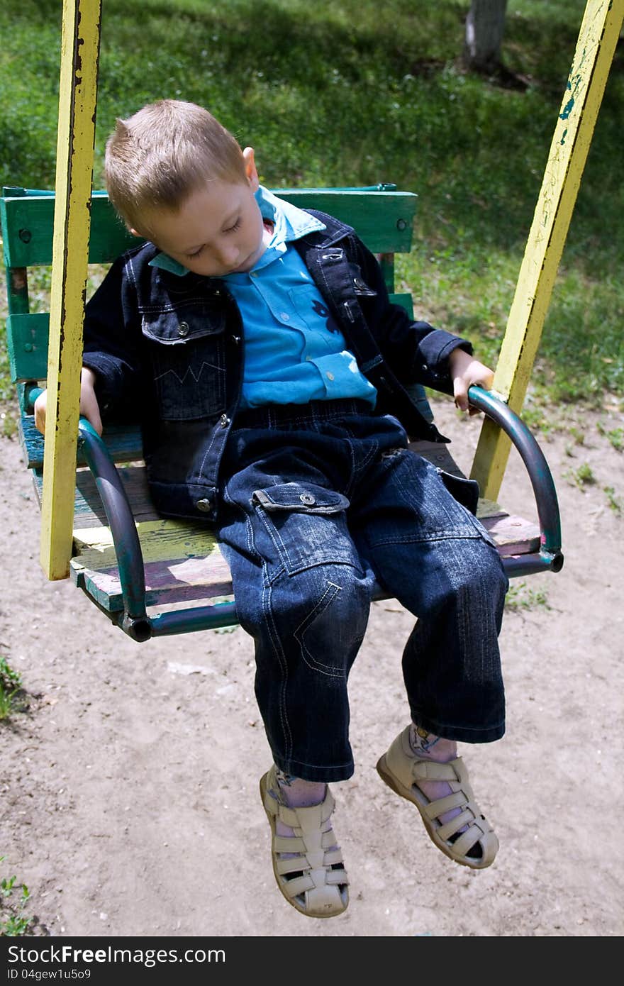 Little boy fell asleep in the swing riding. Little boy fell asleep in the swing riding