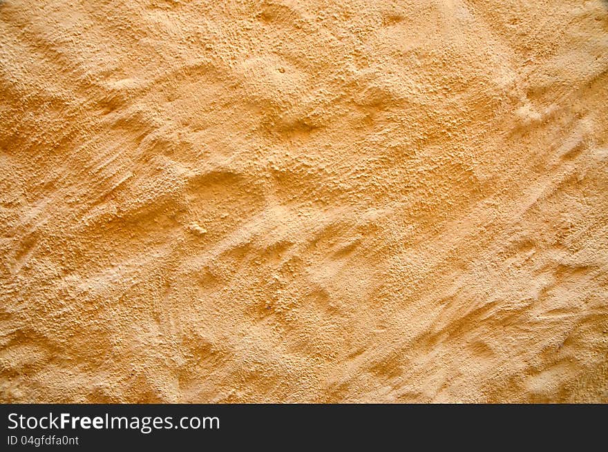 Background of a warm wall with rough plaster texture. Light brown, yellow, ocher, is typical of Sardinia, Italy. Background of a warm wall with rough plaster texture. Light brown, yellow, ocher, is typical of Sardinia, Italy.