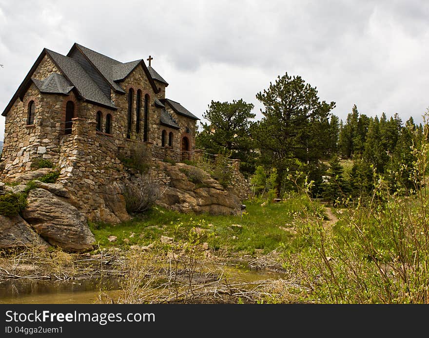 A rustic stone church under a grey cloudy sky. A rustic stone church under a grey cloudy sky.