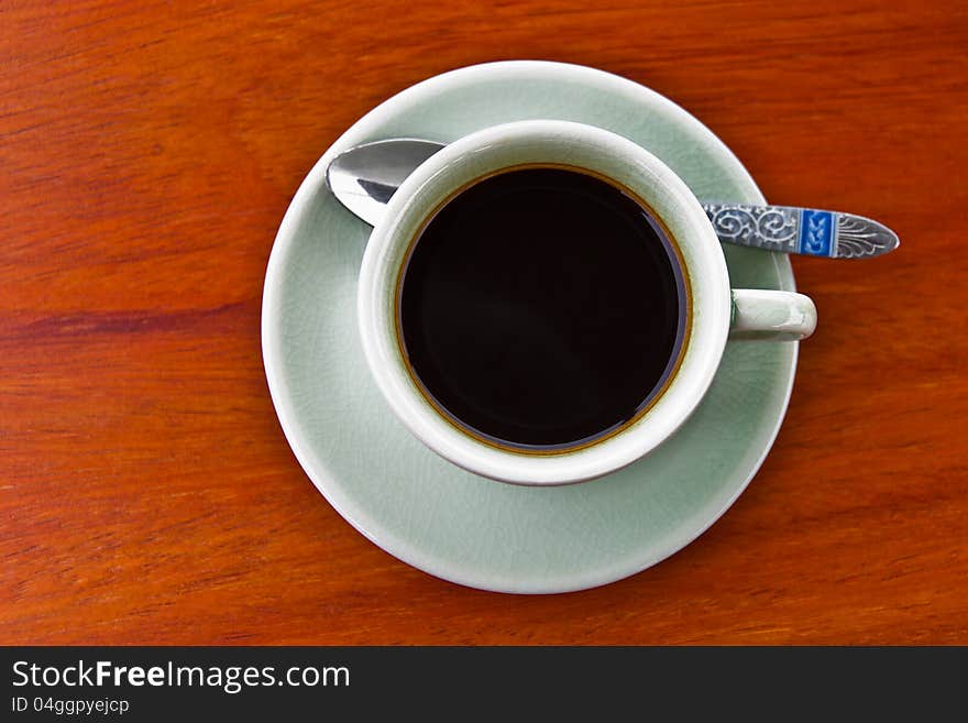 A cup of hot espresso on wooden table, top view