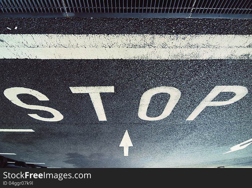 Warning STOP sign on the pavement at the car parking by night. Warning STOP sign on the pavement at the car parking by night