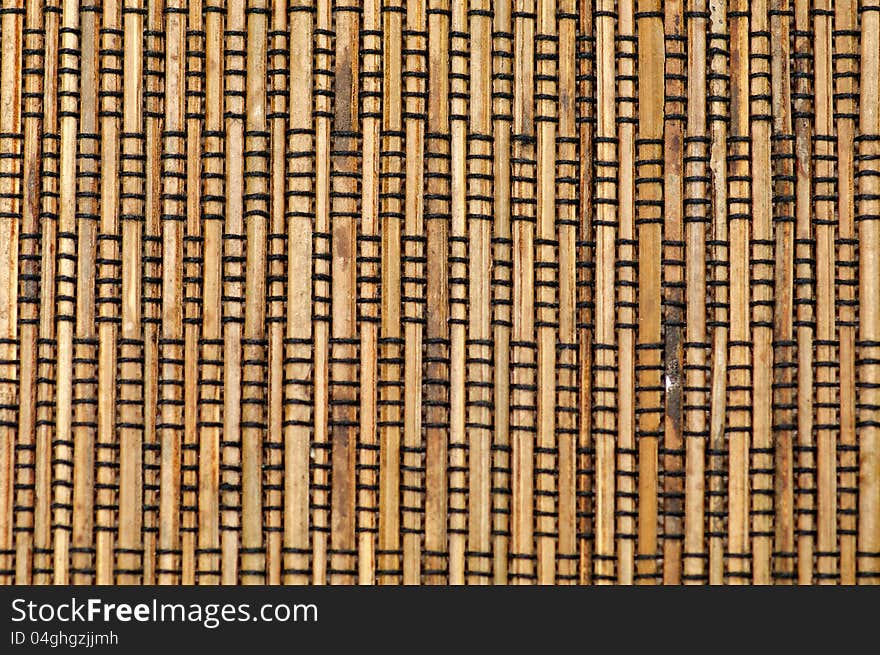 Bamboo mat with black thread closeup as background