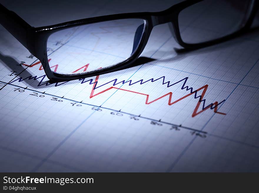 Business concept. Closeup of spectacles on graph paper with diagram. Business concept. Closeup of spectacles on graph paper with diagram