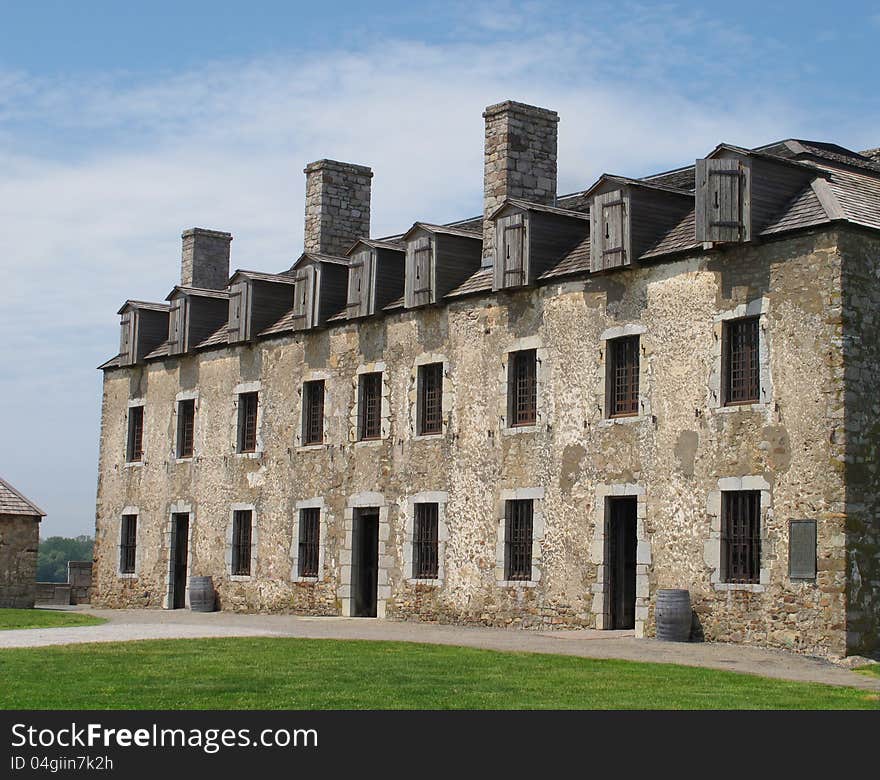 Two story old stone soldier barracks with chimneys and wood dormers along the roof. Two story old stone soldier barracks with chimneys and wood dormers along the roof.