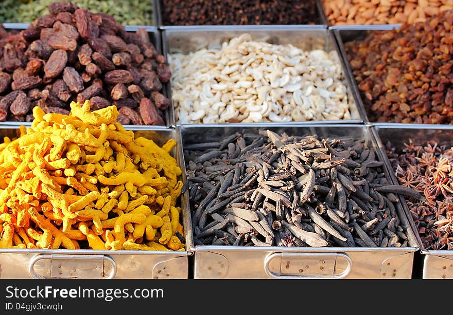 Dry fruits and spices like cashews, raisins, turmeric, cloves, anise, etc. on display in containers for sale in a bazaar in bangalore, india. Dry fruits and spices like cashews, raisins, turmeric, cloves, anise, etc. on display in containers for sale in a bazaar in bangalore, india.