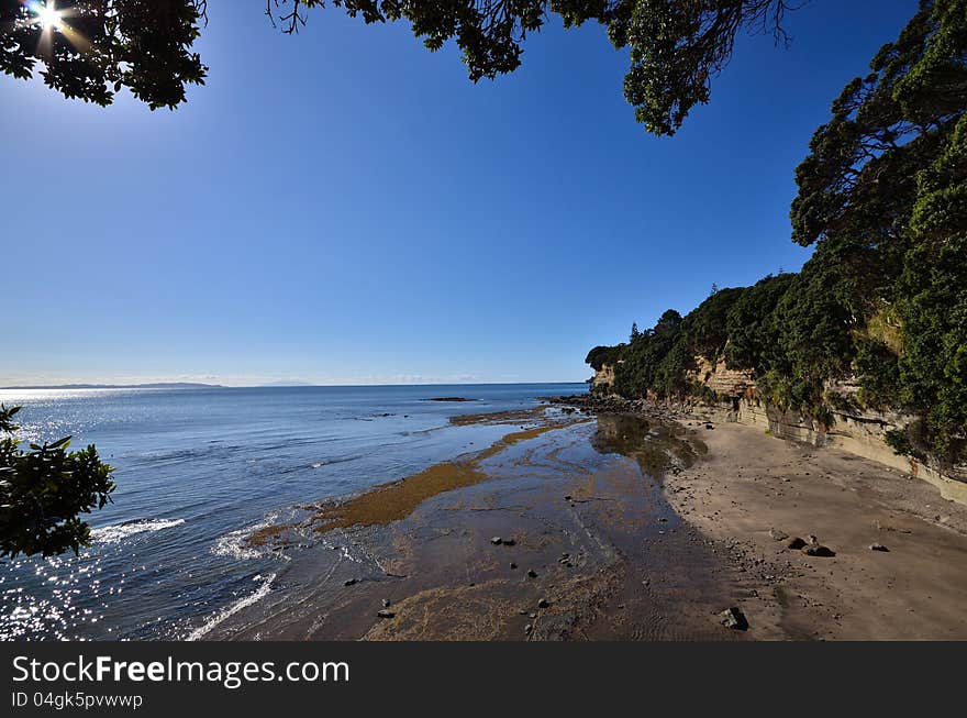 A view of a small beach at the base of cliffs. A view of a small beach at the base of cliffs.