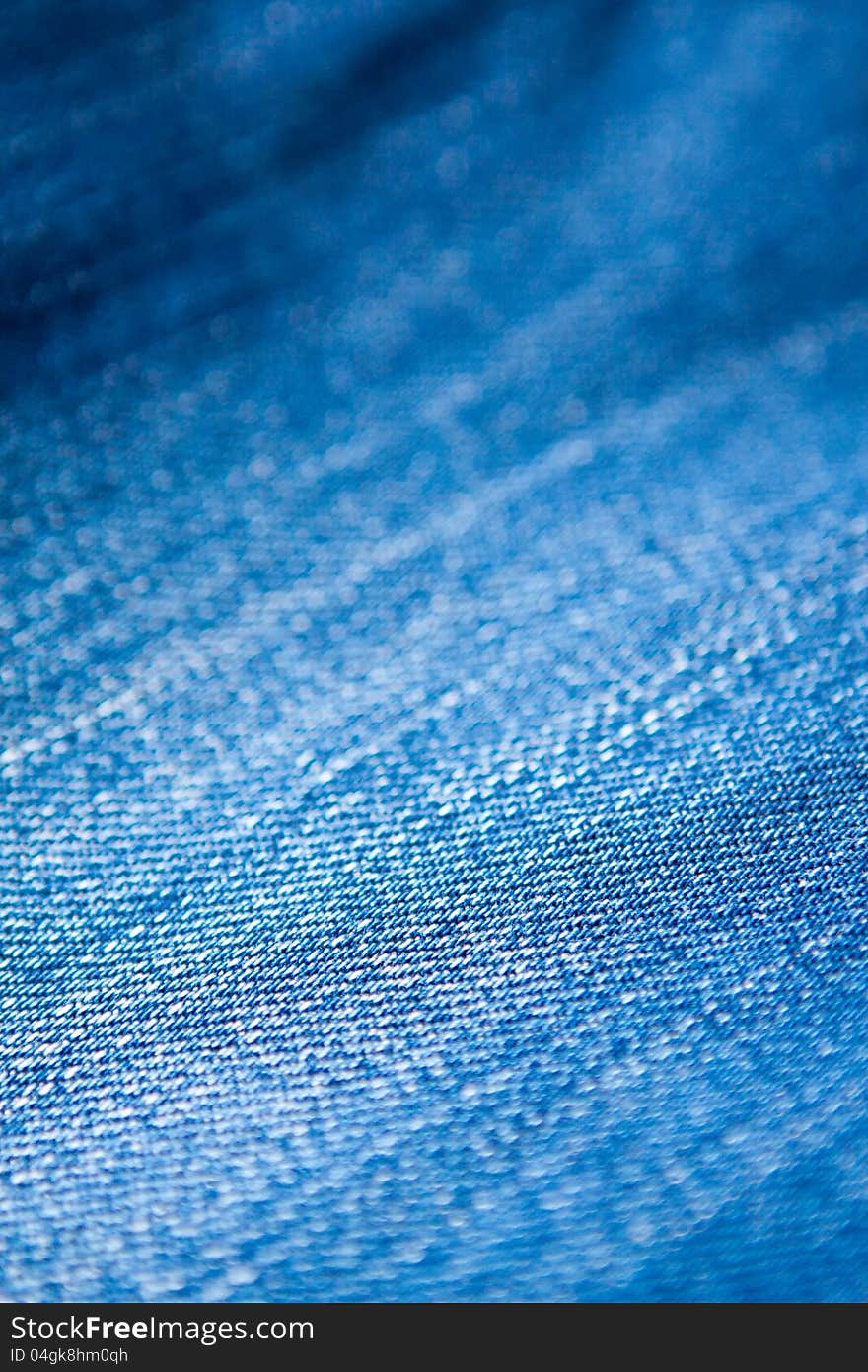 Closeup texture of blue denim jeans material showing the detail and texture of the weave. Closeup texture of blue denim jeans material showing the detail and texture of the weave