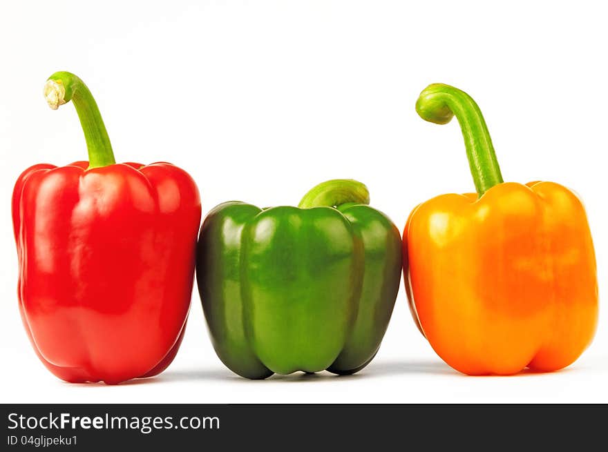 Three luscious colored peppers are on white background. Three luscious colored peppers are on white background