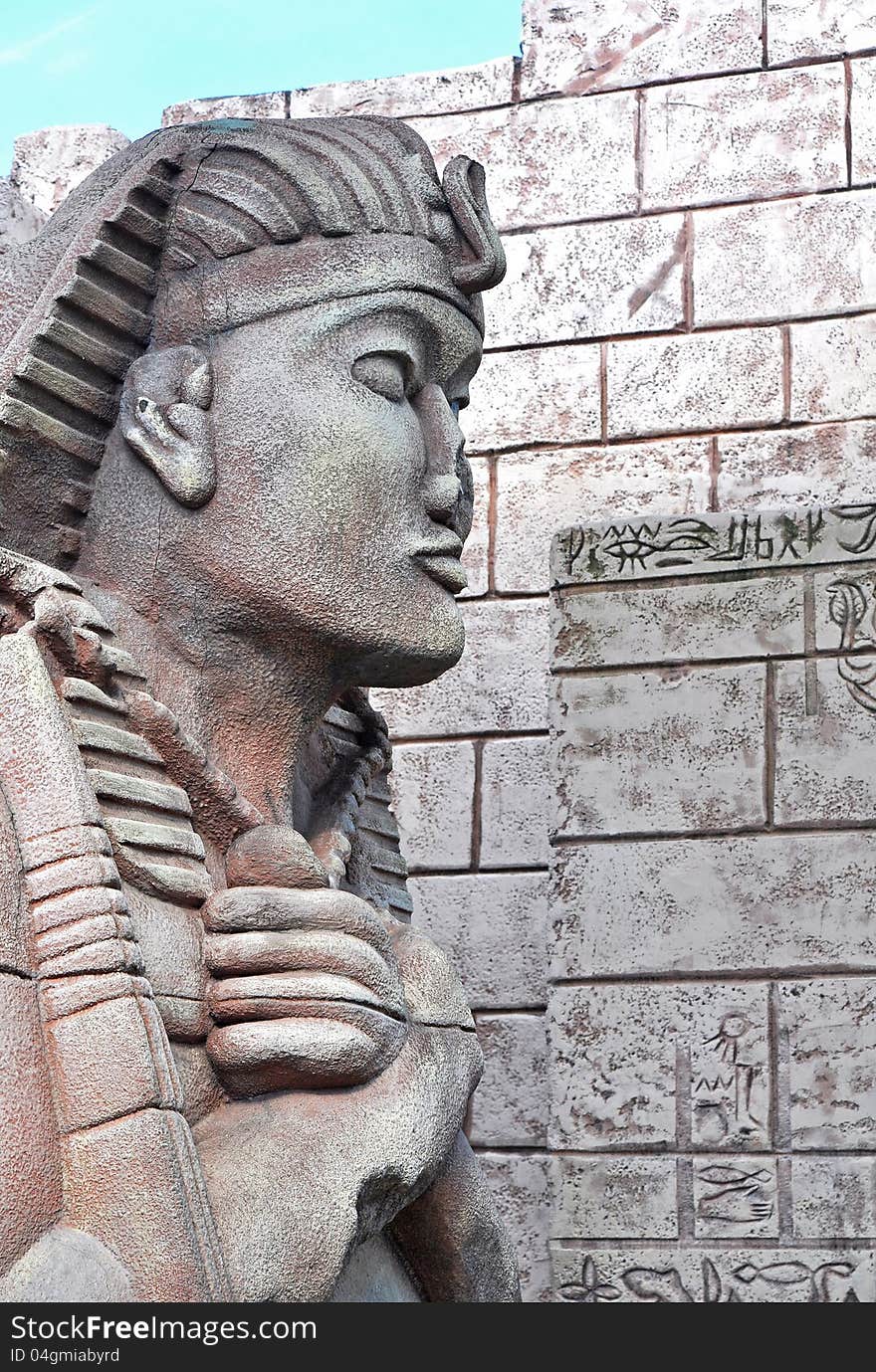 Sphinx head closeup and Egyptian wall background, vertical