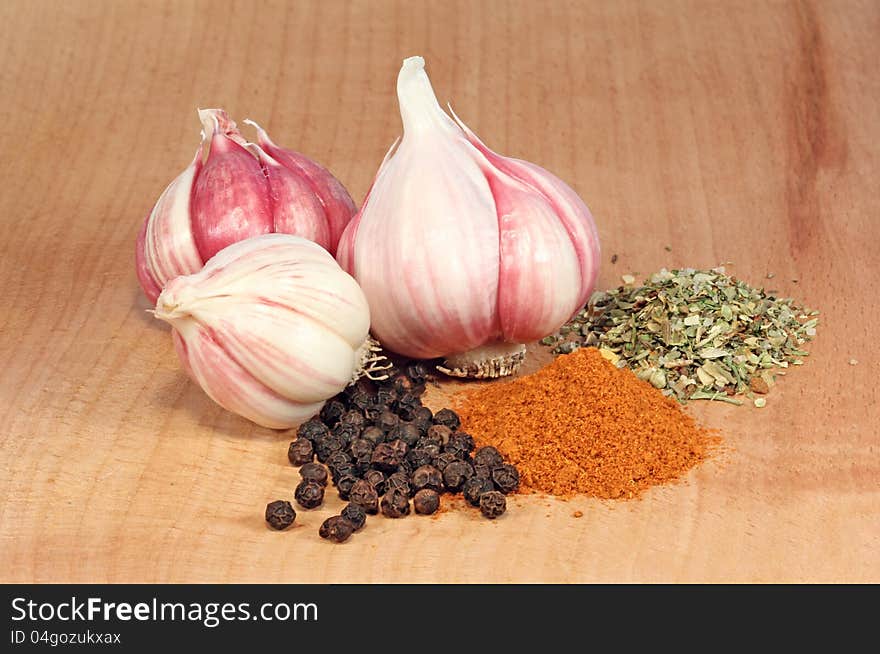 Fresh garlic and spices on a wooden table