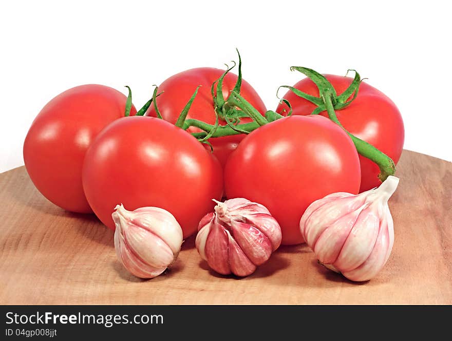 Fresh tomatoes and garlic on a wooden table