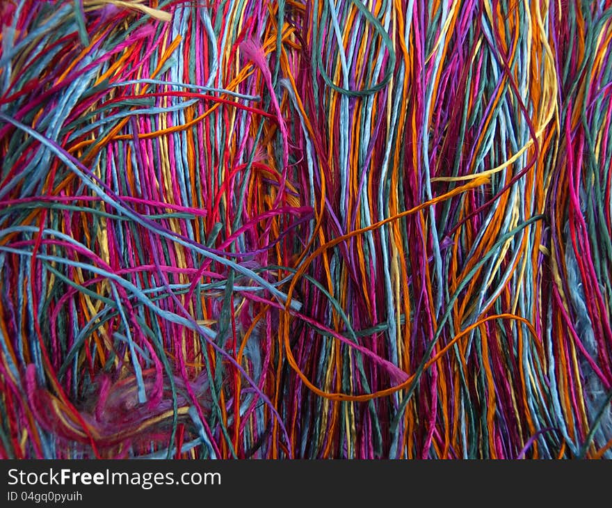 Vivid silk colored thread on a table. Vivid silk colored thread on a table