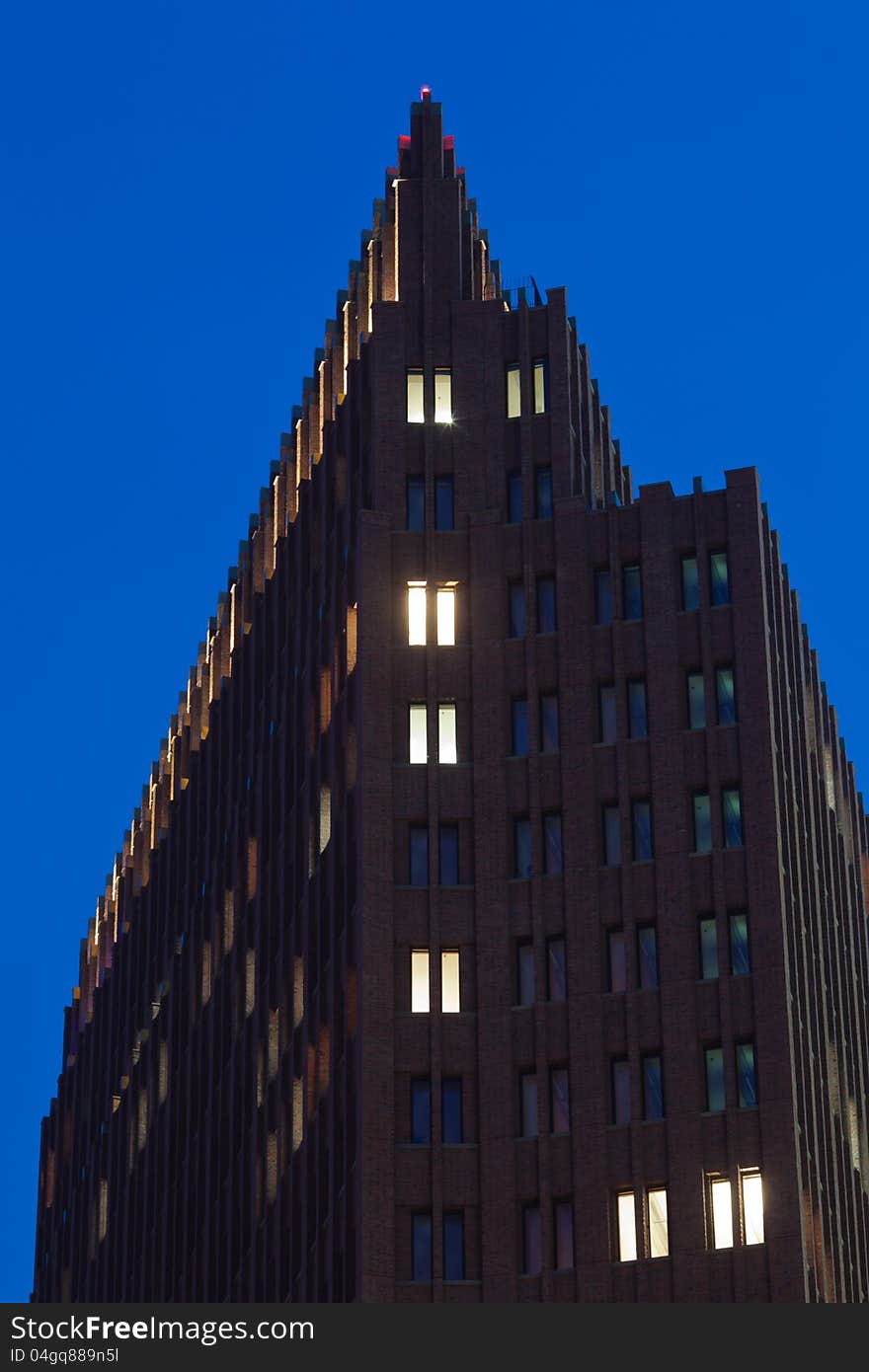 Tower building with lightened windows at blue night sky. Tower building with lightened windows at blue night sky