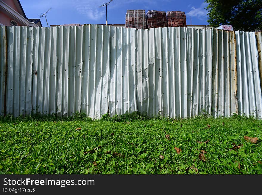 Picture of a fence separating two neighbors. Can be used as a background or to illustrate a division. Picture of a fence separating two neighbors. Can be used as a background or to illustrate a division.