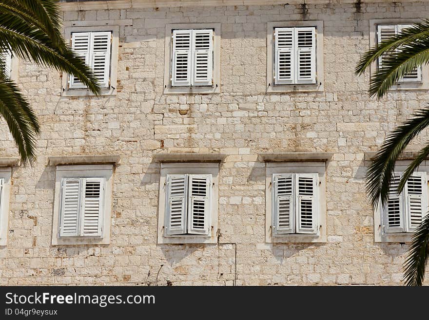 Stony wall and windows with white shutters in Trogir - Croatia. Stony wall and windows with white shutters in Trogir - Croatia.