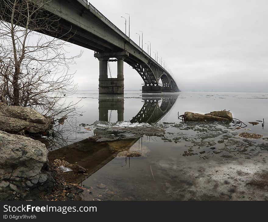 The bridge through the river in cloudy day. panorama from vertical shots. The bridge through the Volga River in Saratov.