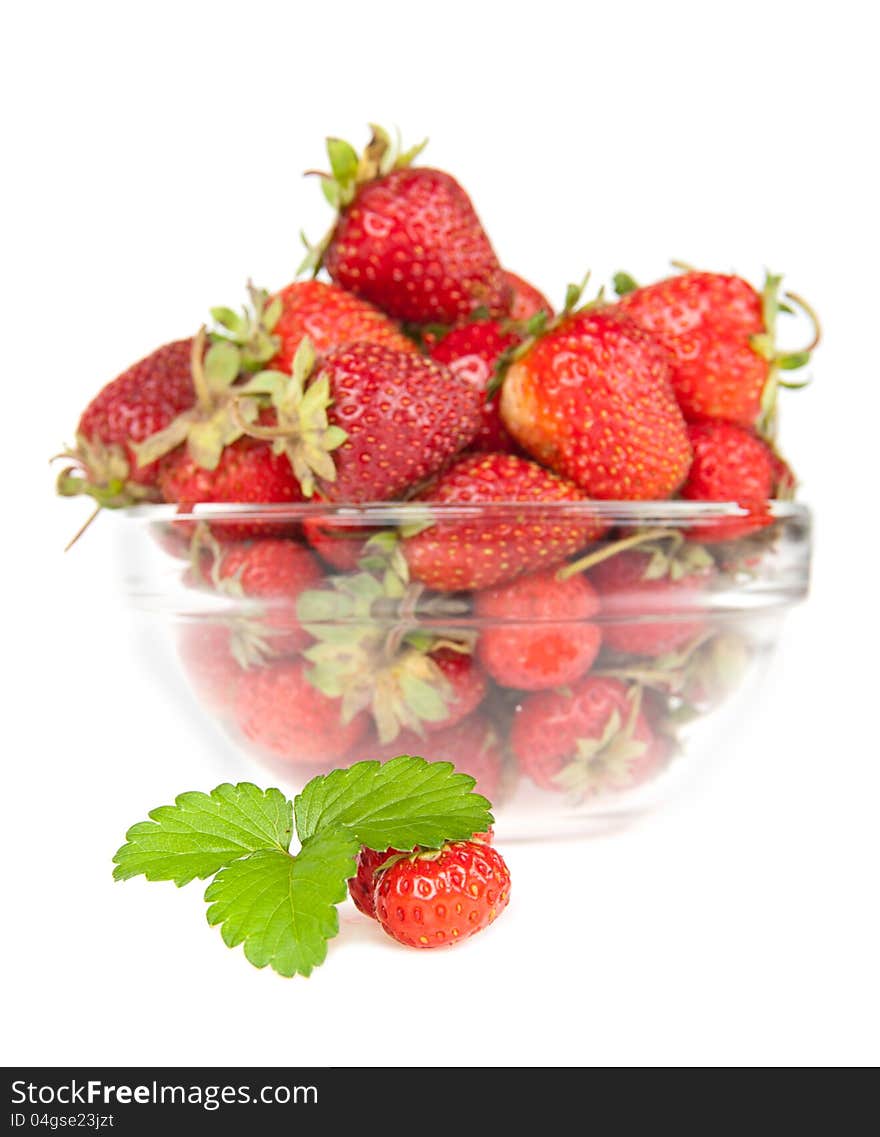 Berry of strawberry with a sheet on a background a dish with a strawberry