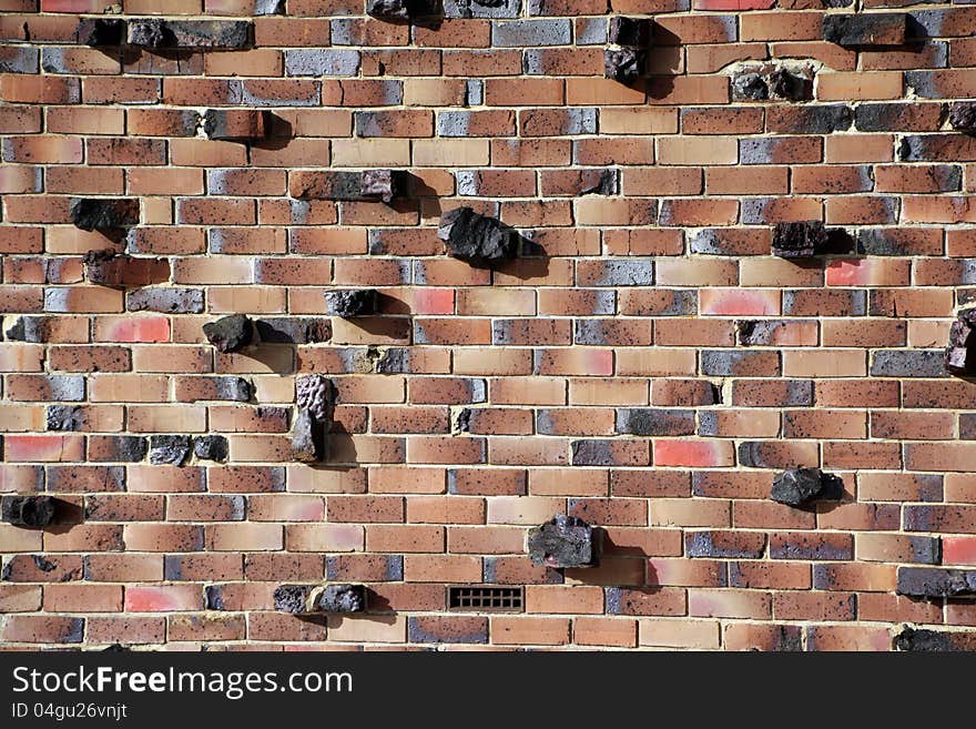 Pieces of rock have been inserted with the clay bricks to create a modern brick wall of cream, brown, red, and grey colouring with character and texture. Pieces of rock have been inserted with the clay bricks to create a modern brick wall of cream, brown, red, and grey colouring with character and texture.