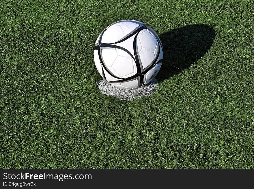 Football ball on apenalti point on a green grass