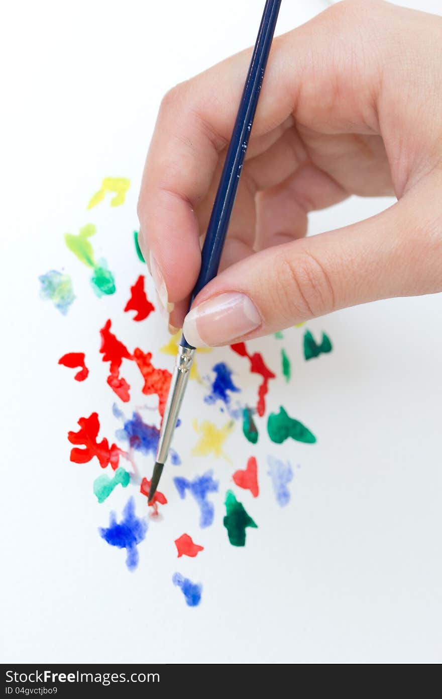 Hand with brush and watercolor paint