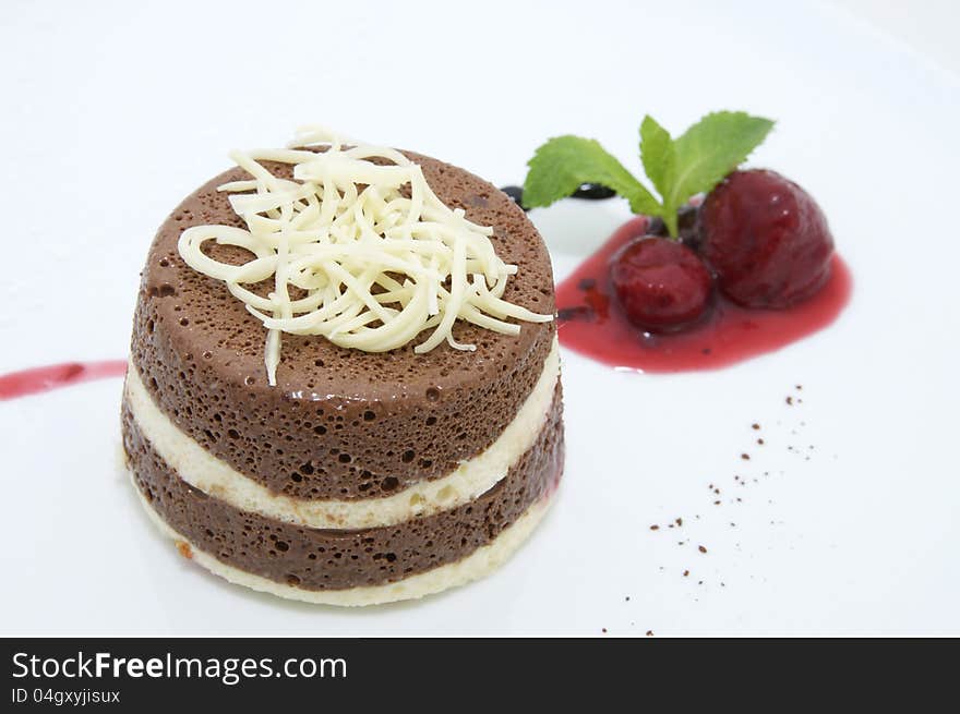 A piece of cream cake decorated with chocolate and mint. A piece of cream cake decorated with chocolate and mint