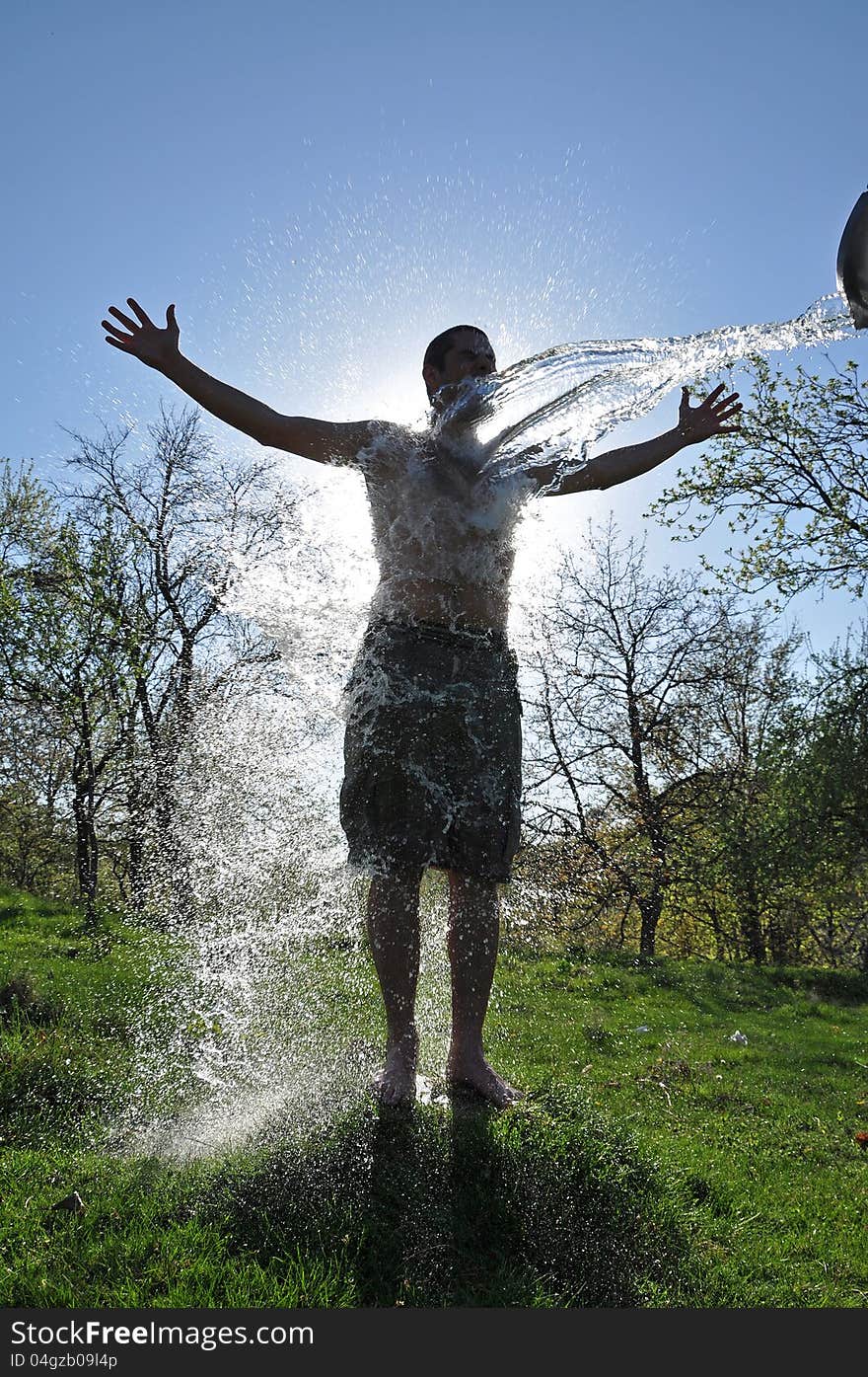 Male enjoys the water splash in the outdoors