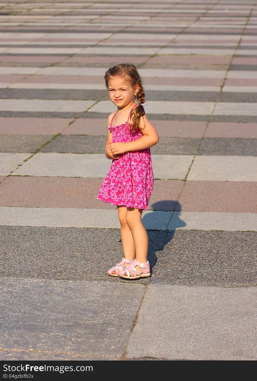 Alone little girl on a huge empty square