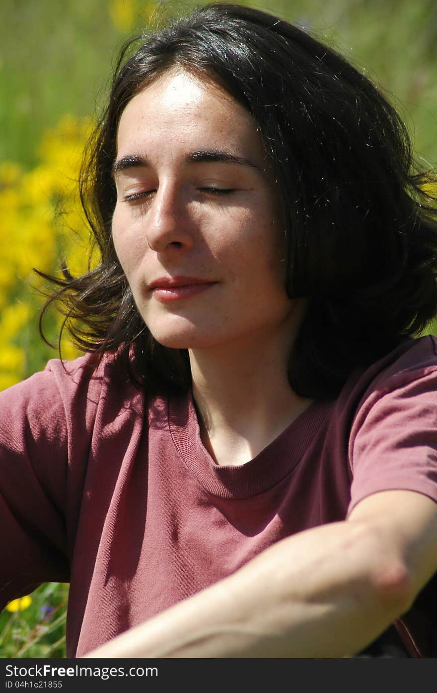 A beautiful young woman portrait in the middle of a meadow with flowers