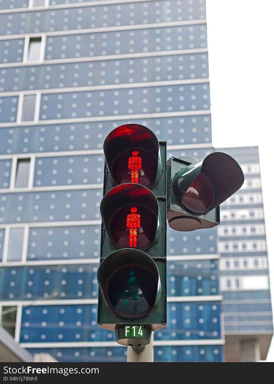 You see a traffic light in Hamburg with the red stop signal for people.