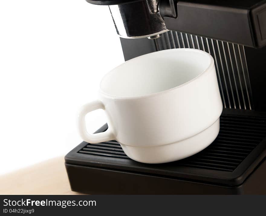 Close up coffee maker machine with white coffee cup